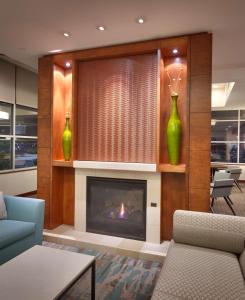 a living room with a fireplace and two green vases at Hyatt House Salt Lake City/Sandy in Sandy