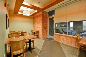 a dining room with a brick wall and tables and chairs at Hyatt Place Chicago/Naperville/Warrenville in Warrenville