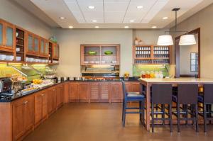 uma grande cozinha com armários de madeira e uma grande ilha em Hyatt Place San Diego-Vista/Carlsbad em Vista