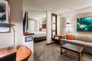 a hotel room with a couch and a bed at Hyatt Place Atlanta Duluth Johns Creek in Johns Creek