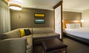 um quarto de hotel com um sofá e uma cama em Hyatt Place Daytona Beach-Oceanfront em Daytona Beach