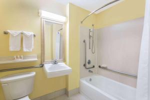 a bathroom with a white toilet and a sink at Baymont by Wyndham Savannah Midtown in Savannah