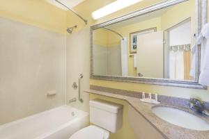 a bathroom with a sink and a toilet and a mirror at Baymont by Wyndham Savannah Midtown in Savannah