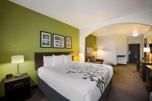 コルビーにあるSleep Inn & Suitesの大きなベッドとデスクが備わるホテルルームです。