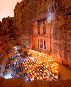 a group of people standing in front of a cave at cabin hotel in Ma‘ān