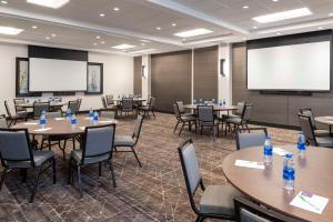 a conference room with tables and chairs and a projection screen at Hyatt Place Detroit/Royal Oak in Royal Oak