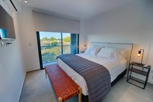a bedroom with a large bed and a balcony at Apartemanto Luxury vistas Nqn 1 bed in Neuquén
