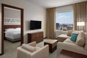 una camera d'albergo con letto e TV di Hyatt House Jeddah Sari Street a Gedda