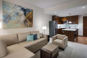 a living room with a couch and a kitchen at Hyatt House Jeddah Sari Street in Jeddah
