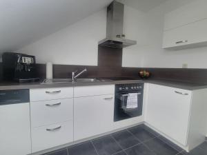 a kitchen with white cabinets and a sink at Ruhige Ferienwohnung auf dem Land in Starzach +11 photos