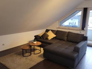 a living room with a black couch and a window at Ruhige Ferienwohnung auf dem Land in Starzach