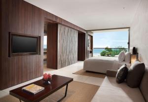 a hotel room with a bed and a television at Alila Seminyak in Seminyak