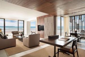 a living room with a table and chairs and a television at Alila Seminyak in Seminyak