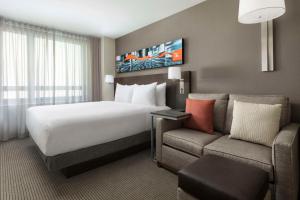 a hotel room with a bed and a couch at Hyatt Place New York City/Times Square in New York