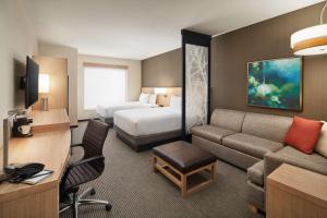 a hotel room with a couch and a bed at Hyatt Place Melbourne - Palm Bay - I-95 in Melbourne