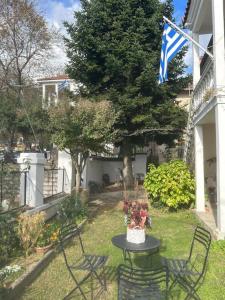 une table et des chaises dans une cour avec drapeau dans l'établissement La Casa di Rena, à Ano Poroia
