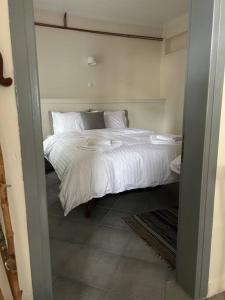 1 dormitorio con 1 cama con sábanas y almohadas blancas en La Casa di Rena, en Áno Poróïa