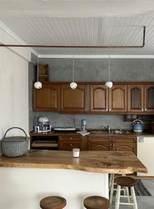 une cuisine avec des placards en bois et une table en bois dans l'établissement La Casa di Rena, à Ano Poroia