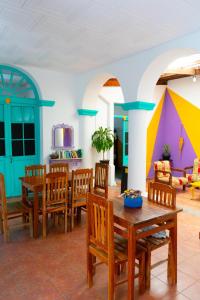 una sala de estar con mesas y sillas de madera. en Casa Blanca Hostel, en Tarija