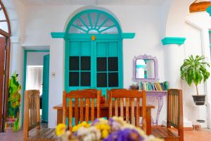 een eetkamer met een tafel en stoelen en een blauwe deur bij Casa Blanca Hostel in Tarija