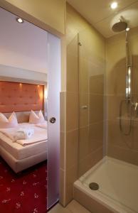 1 dormitorio con 1 cama, ducha y bañera en Hotel Gasthof Zur Post, en Königstein in der Oberpfalz