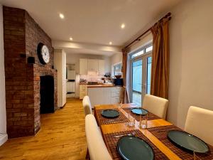 a dining room with a table and a kitchen at Victorian Cottage Like Charm with Modern Comforts in Bristol