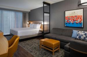 ボストンにあるHyatt Place Boston/Seaport Districtのベッドとソファ付きのホテルルーム