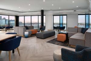 a lobby with couches and chairs and tables and windows at Hyatt Place Boston/Seaport District in Boston