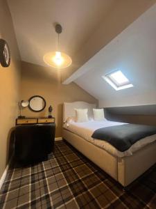 a attic bedroom with a bed and a mirror at Tynwald Apartments in Douglas