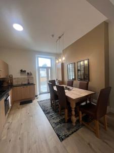 a kitchen and dining room with a table and chairs at Tynwald Apartments in Douglas