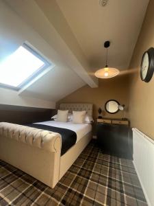 a bedroom with a bed and a clock on the wall at Tynwald Apartments in Douglas