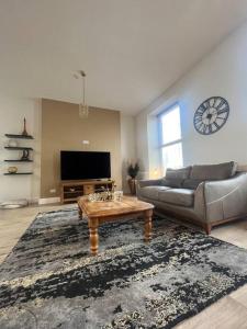 a living room with a couch and a coffee table at Tynwald Apartments in Douglas +45 photos