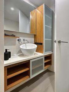 a bathroom with a white bowl sink on a counter at CBD Sky View Apartment in Adelaide