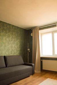 a living room with a couch and a window at Gaujas naktsmājas in Valmiera