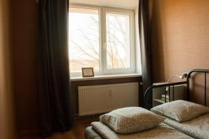 a bedroom with a window and a bed with pillows at Gaujas naktsmājas in Valmiera