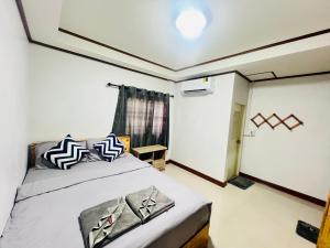 a small room with a bed and a window at Lungwang Guest House in Ban Rak Thai +40 photos