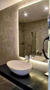 baño con 2 lavabos y espejo grande en Hevea Hotel & Resort, en Ángeles