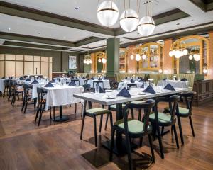 a dining room with tables and chairs and chandeliers at Hyatt House Allentown-Lehigh Valley in Allentown