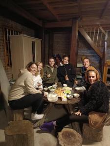 a group of people sitting around a wooden table at Má Si H'MÔNG HOMESTAY Tả Phìn in Sapa