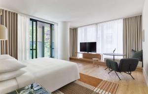 a bedroom with a bed and a table and a television at Hyatt Centric Melbourne in Melbourne