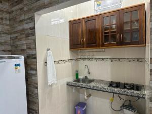 eine kleine Küche mit Spüle und Kühlschrank in der Unterkunft Studio Executivo no Centro de Santarém - WIFI e Central de Ar in Santarém + 13 Fotos