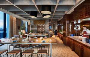 un restaurante con mesas y sillas y gente de fondo en Hyatt Centric Melbourne en Melbourne