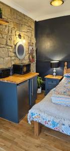 a bedroom with a bed and a stone wall at Amble Harbour retreats in Amble