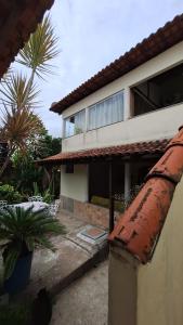 Uma casa com um cano enferrujado à frente. em casa suite cabo frio em Cabo Frio