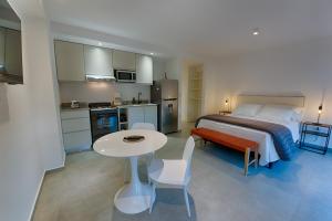 a bedroom with a bed and a table and a kitchen at Apartamento Luxury Vistas E in Neuquén