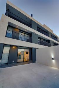 an apartment building with a parking lot in front of it at Apartamento Luxury Vistas E in Neuquén