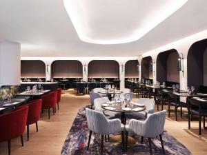 ein Restaurant mit Tischen und Stühlen in einem Zimmer in der Unterkunft Hyatt Regency London Stratford in London