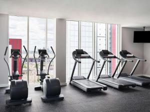 a gym with cardio equipment in a room with a large window at Hyatt Regency London Stratford in London