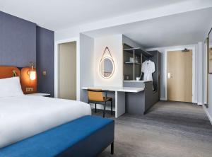 a hotel room with a bed and a desk at Hyatt Regency London Stratford in London