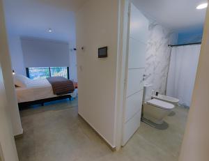 a bathroom with a toilet and a bedroom with a bed at Apartamento Luxury Vistas E in Neuquén
